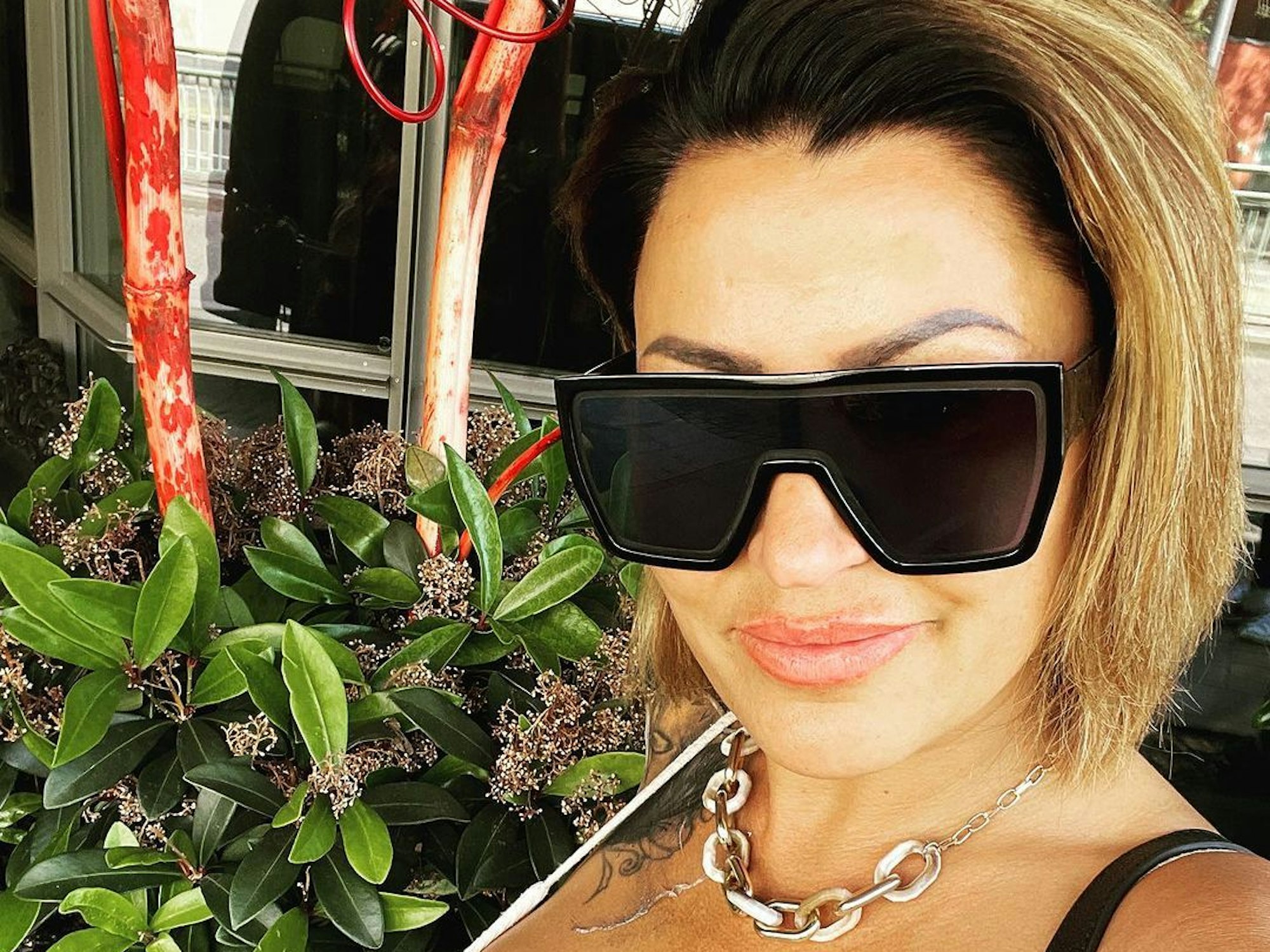 Jasmin Herren posiert im weißen Top und Sonnenbrille für ein Foto.