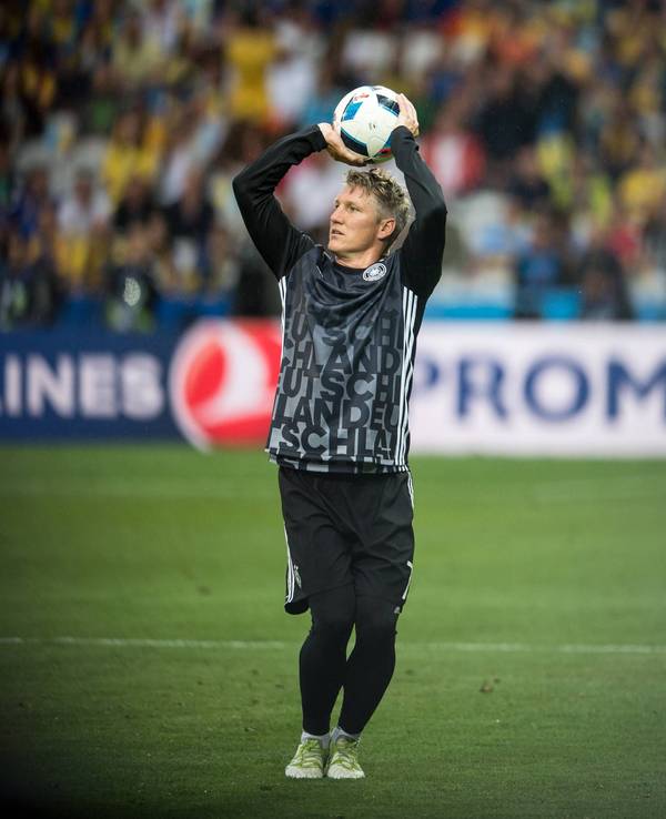 Bastian Schweinsteiger wirft einen Fußball wie einen Basketball.