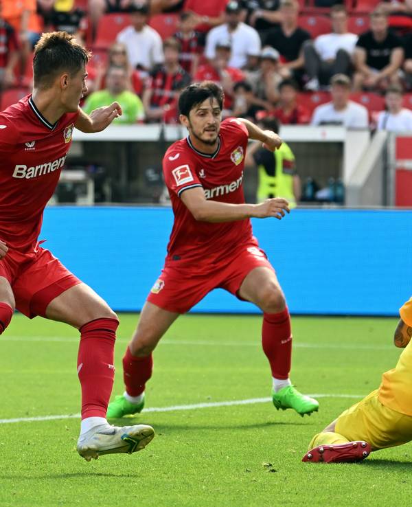 Leverkusens Patrik Schick (l) und Sardar Azmoun (M) und Augsburgs Torwart Rafal Gikiewicz kämpfen um den Ball.