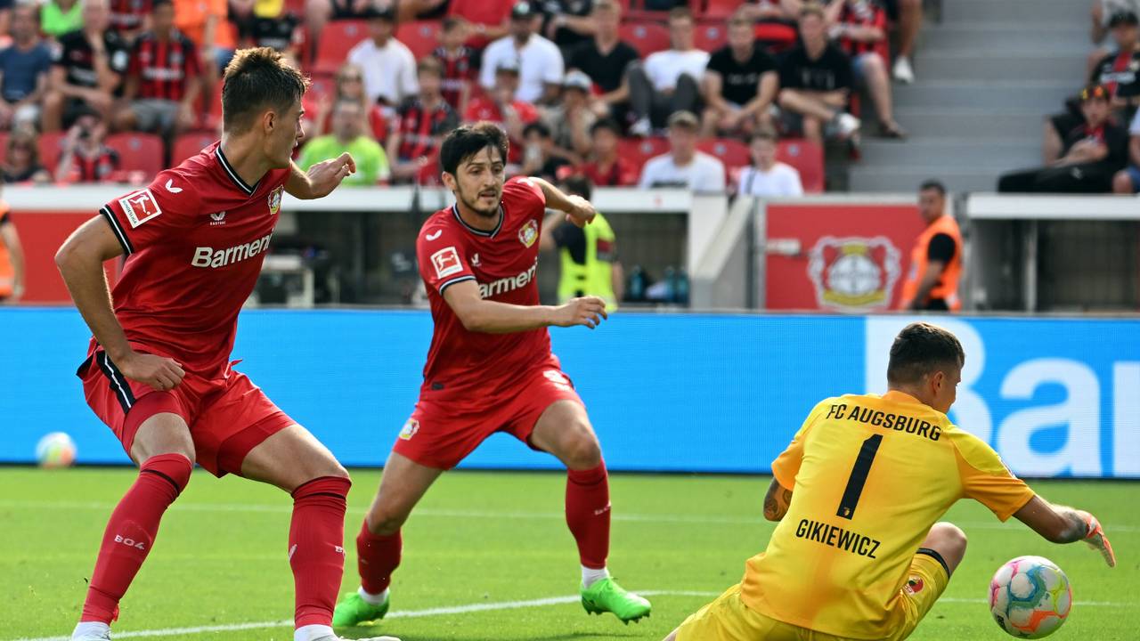 Leverkusens Patrik Schick (l) und Sardar Azmoun (M) und Augsburgs Torwart Rafal Gikiewicz kämpfen um den Ball.