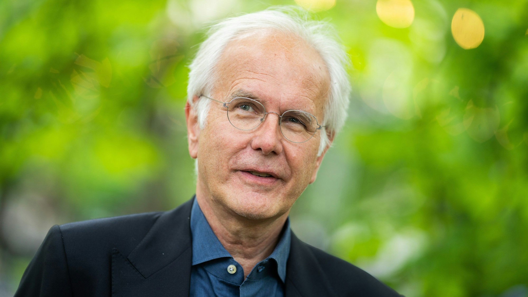 Harald Schmidt mit Jacket vor einem grünen Hintergrund