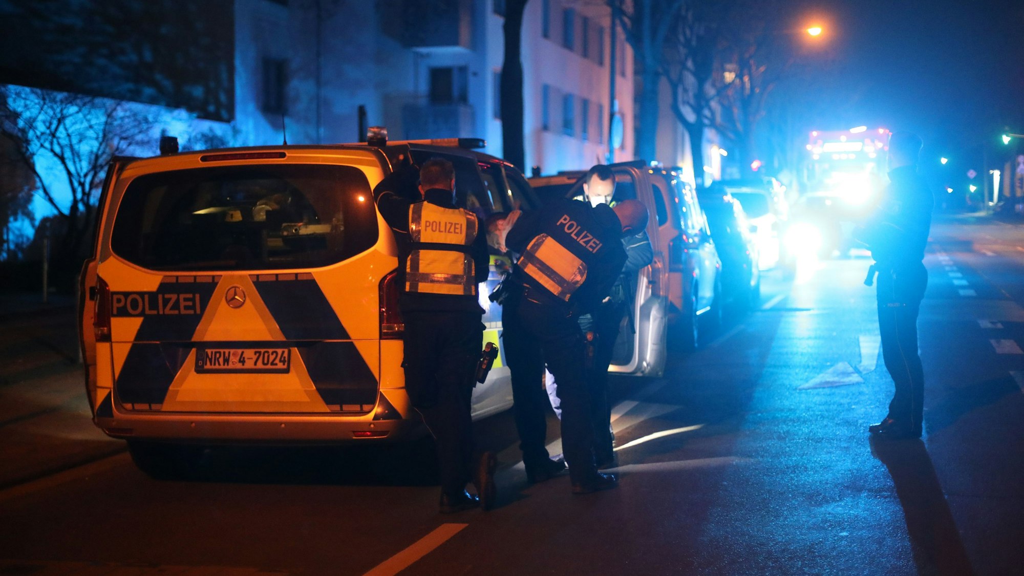 Einsatzkräfte der Polizei stehen an einer Unfallstelle und ermitteln nach einer Verfolgungsfahrt.