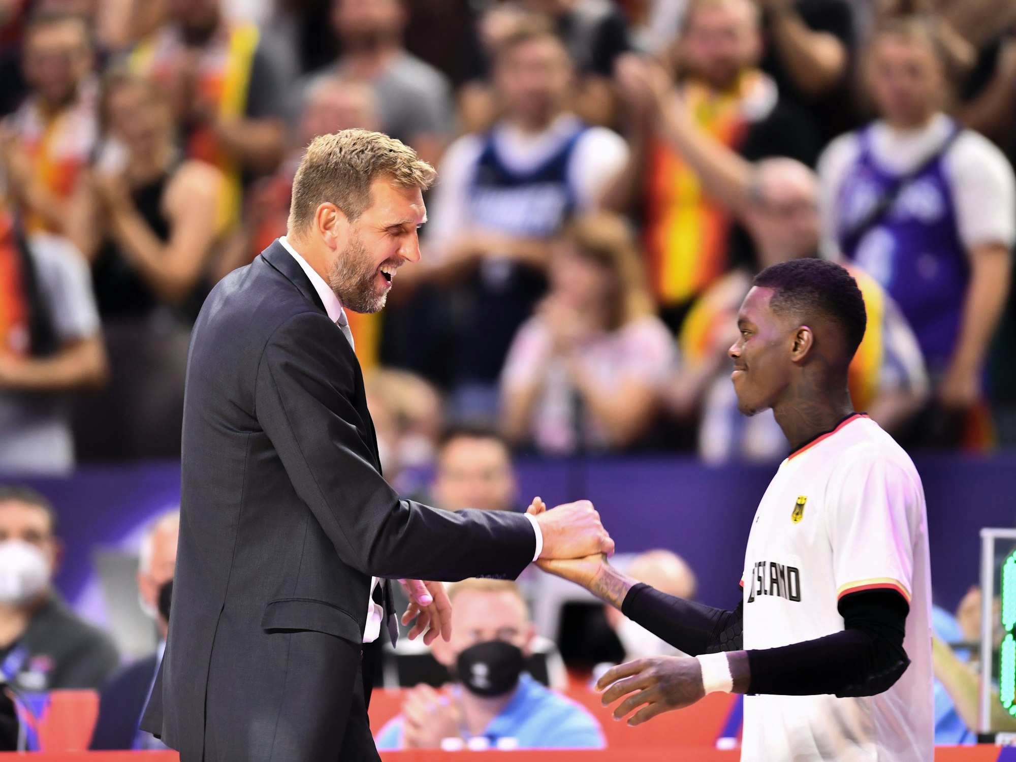 Dirk Nowitzki und Dennis Schröder klatschen im Rahmen des EM-Spiels gegen Frankreich am 01. September 2022 in der Lanxess Arena in Köln ab.