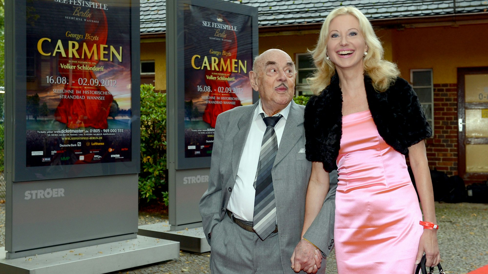 Artur Brauner schaut die lächelnde Manuela Tischler 2012 bei einer Filmpremiere in Berlin an