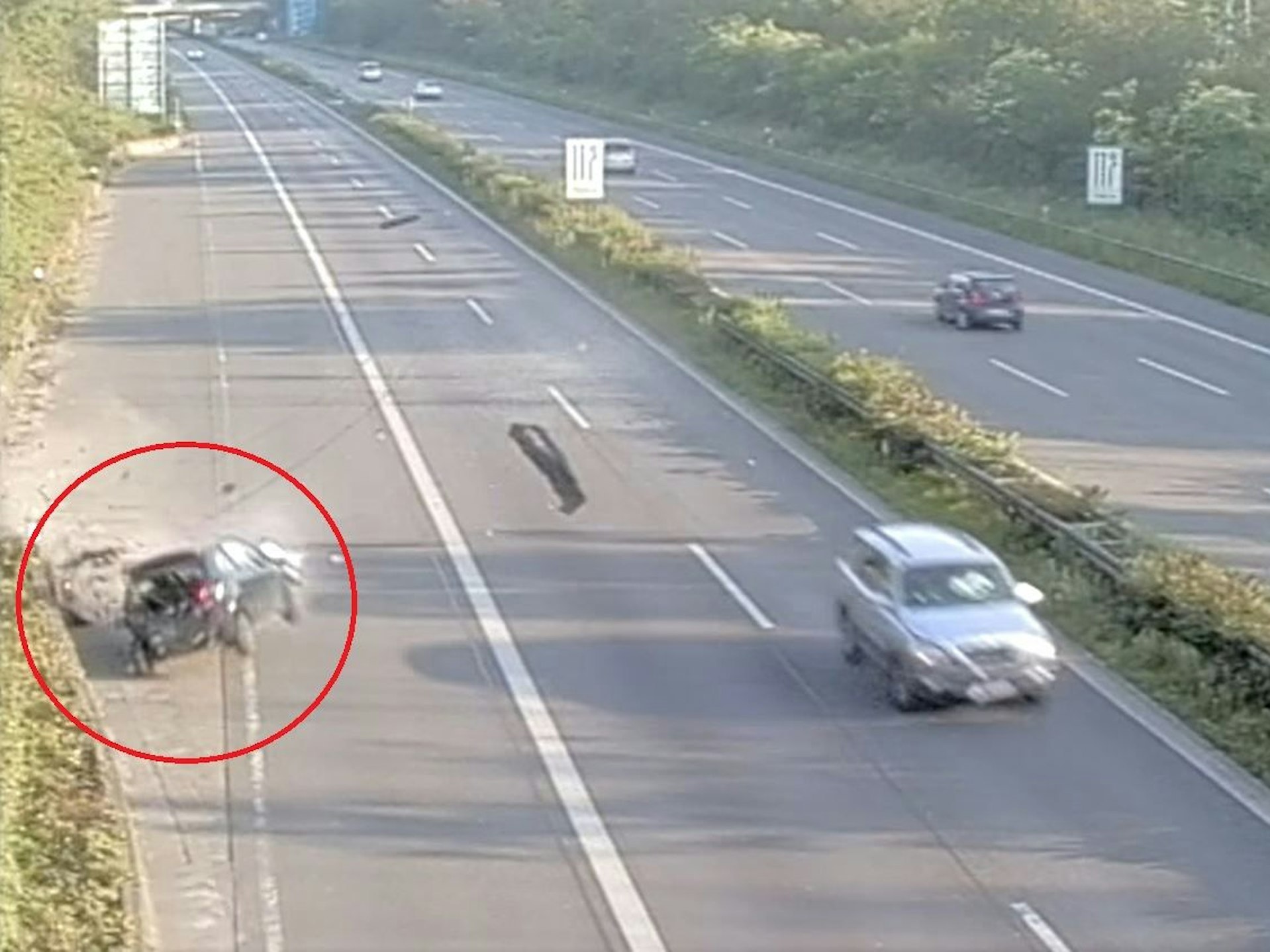 Screenshot aus einem Überwachungsvideo von der A57 in Köln. Gerade kracht ein schwarzes Auto in eine Begrenzungsmauer.