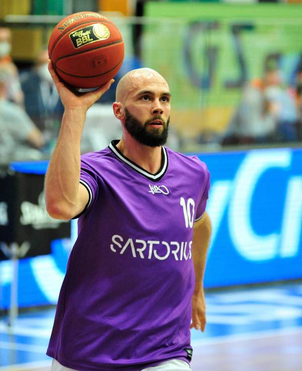 Dennis Kramer hält beim Aufwärmprogramm einen Basketball in der Hand.