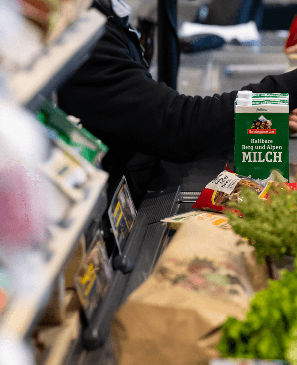 Lebensmittel liegen auf dem Kassenband in einem Supermarkt.