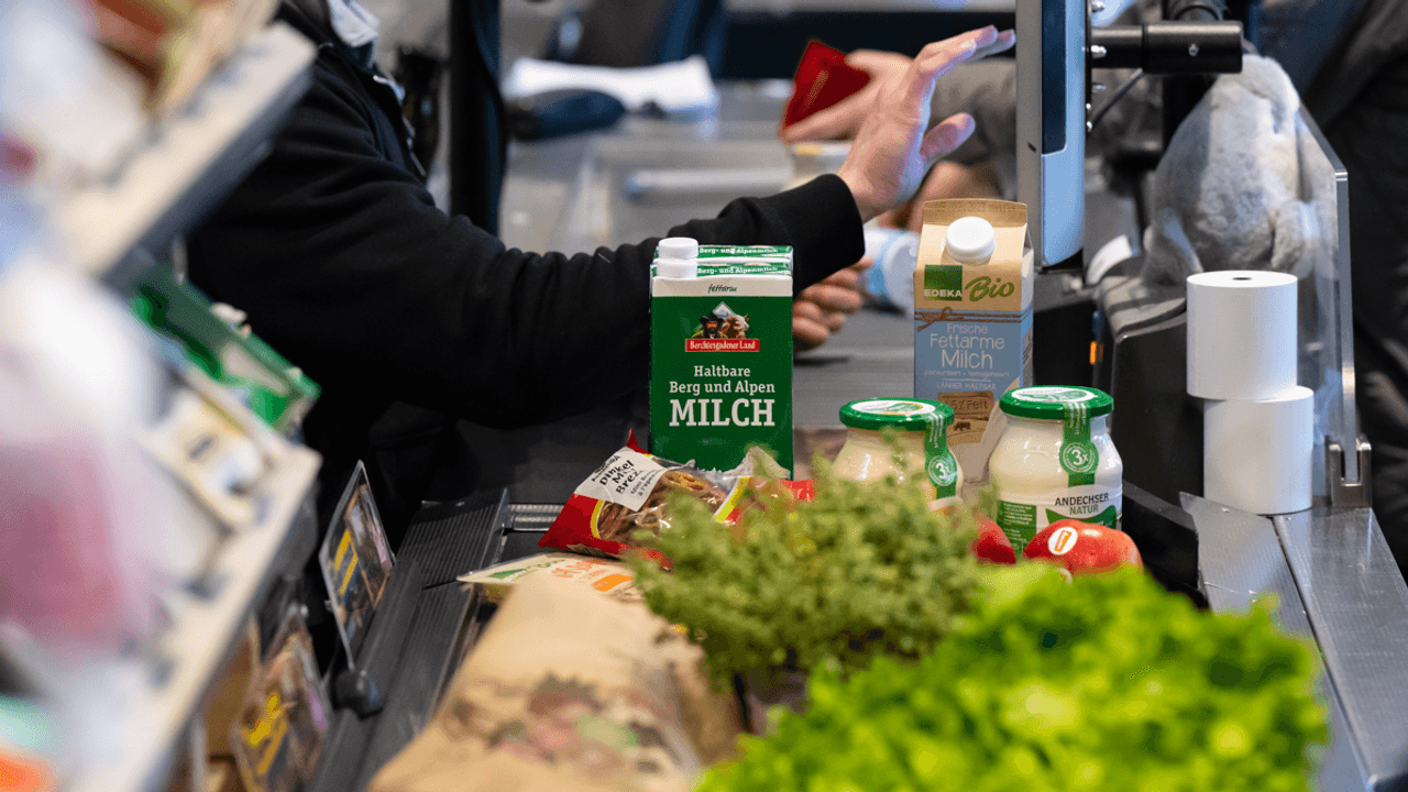 Lebensmittel liegen auf dem Kassenband in einem Supermarkt.