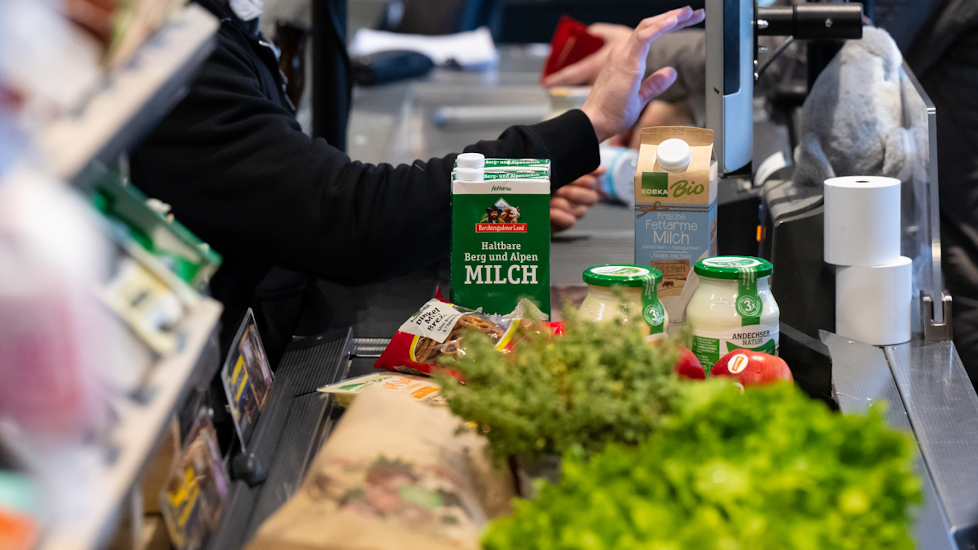Lebensmittel liegen auf dem Kassenband in einem Supermarkt.