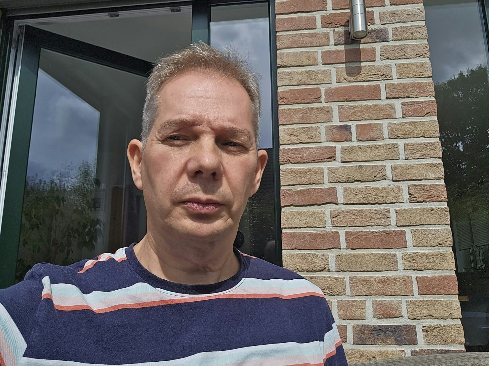 Ein Mann schaut für ein Selfie in die Kamera.