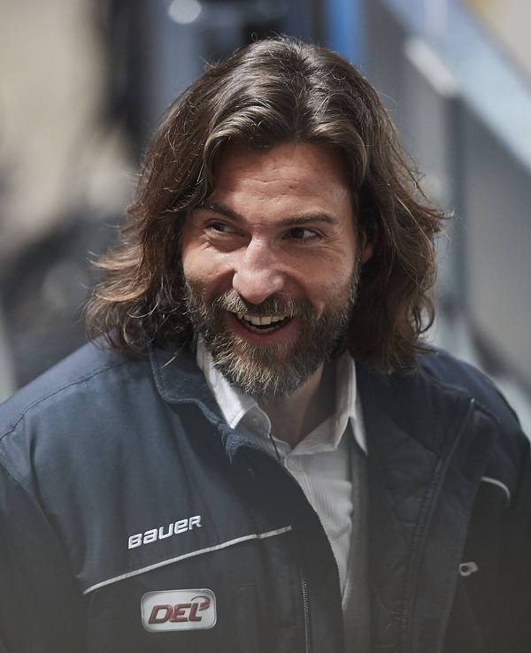 Andreas Renz steht hinter der Bande beim Eishockey-Spiel in München.
