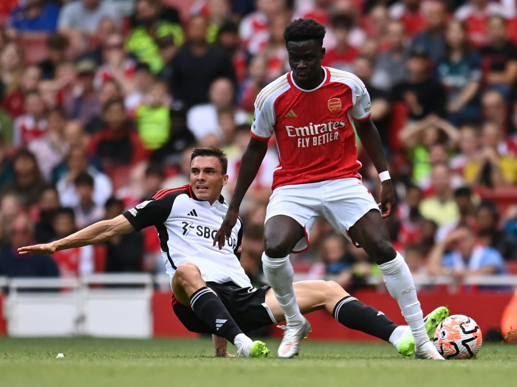 João Palhinha grätscht nach dem Ball. Vor ihm läuft Buyako Saka.