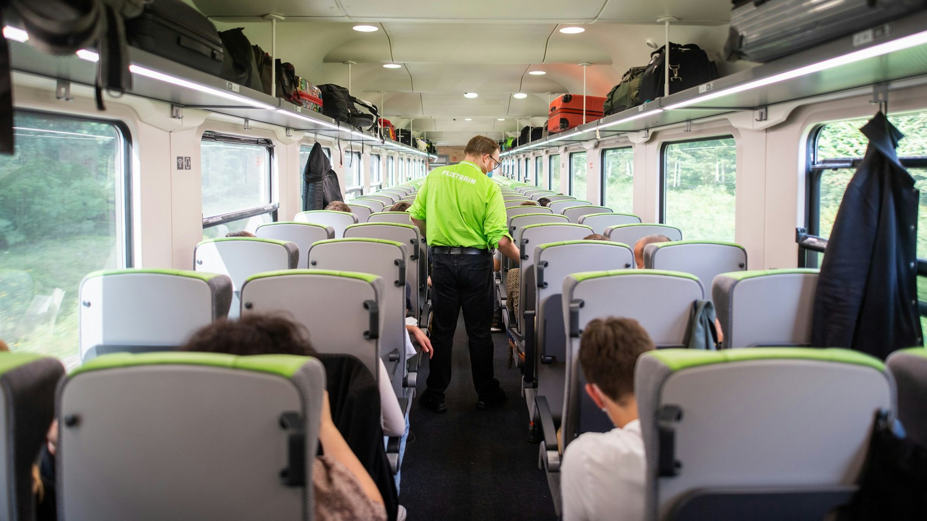 Ein Zugbegleiter geht während einer Fahrt von Hamburg nach Berlin durch einen Flixtrain und kontrolliert die Fahrscheine.