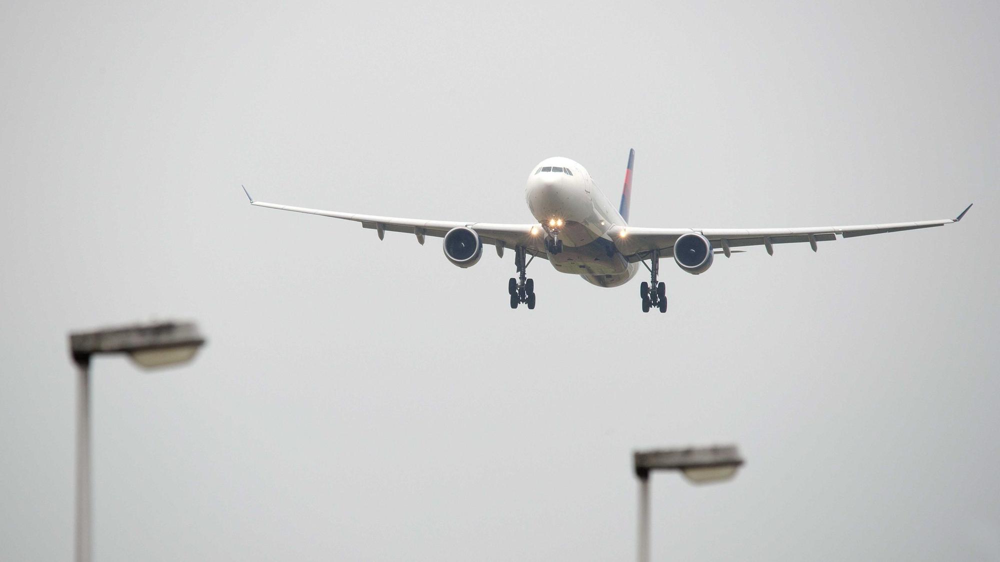 Ein Delta-Flugzeug im Landeanflug vor grauem Himmel.
