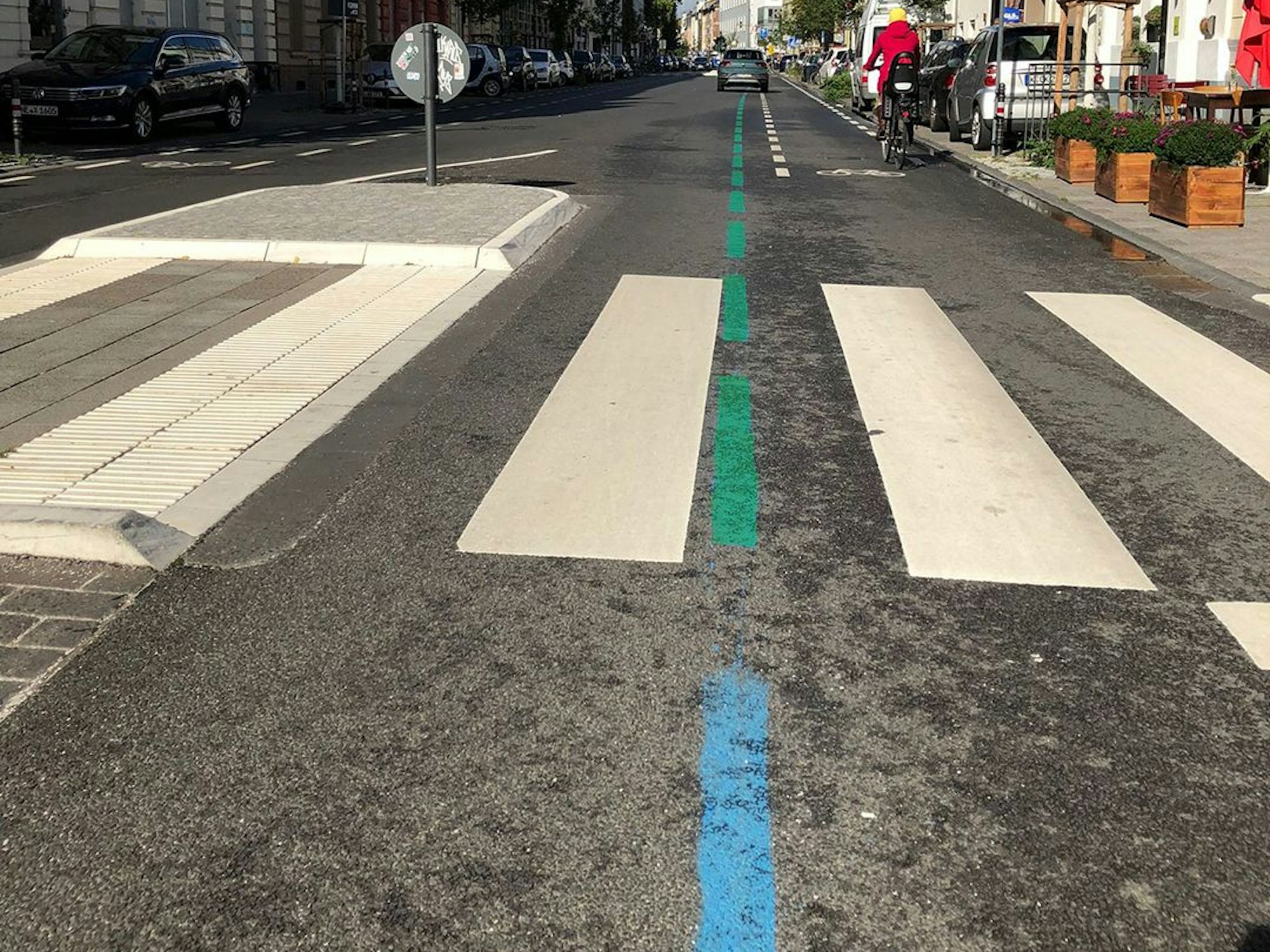 Eine blaue und grüne Linie ist auf dem Asphalt zu sehen.