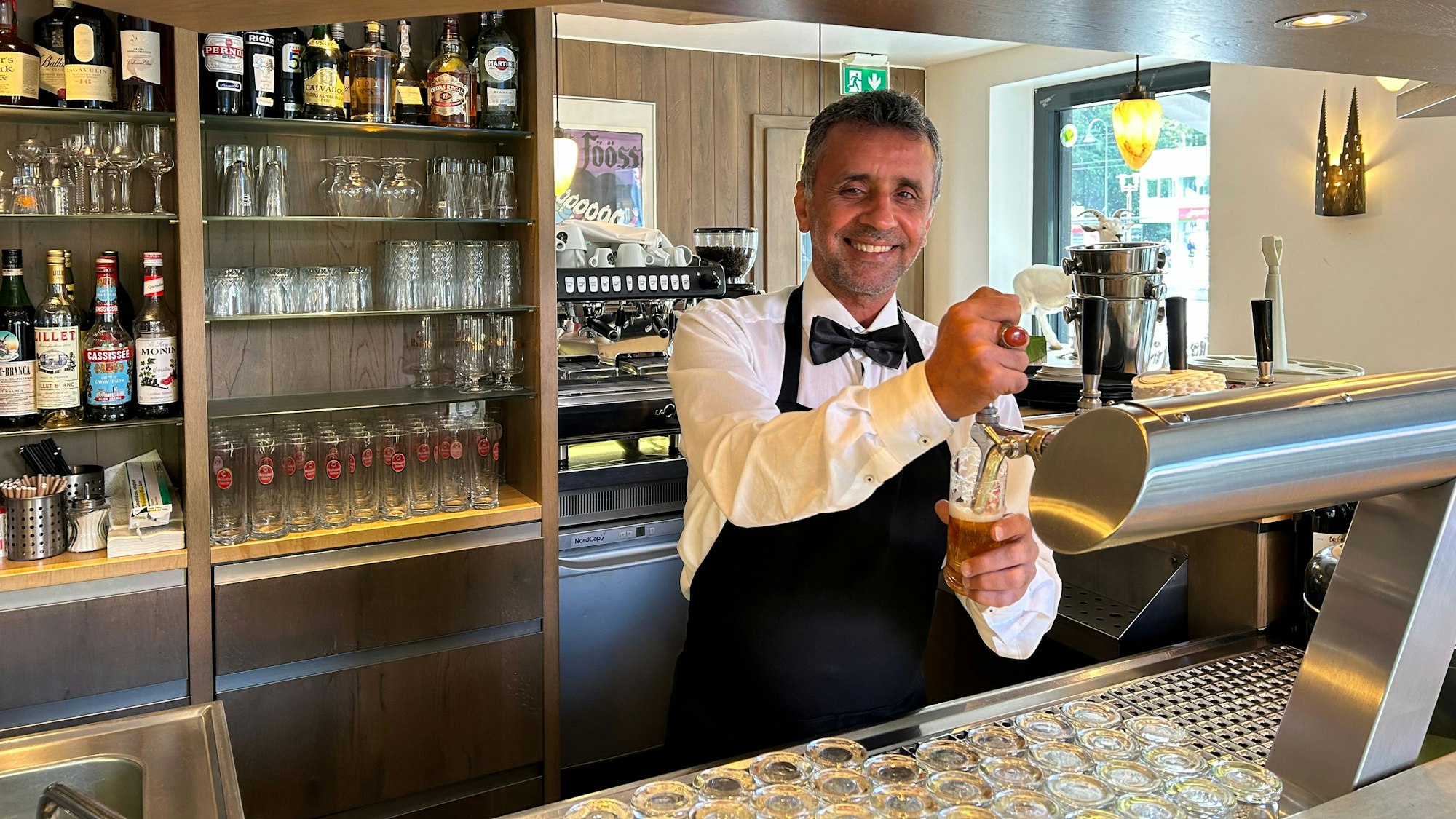 Inhaber Meran Hoveida beim Zapfen eines Glas Kölsch an der Theke