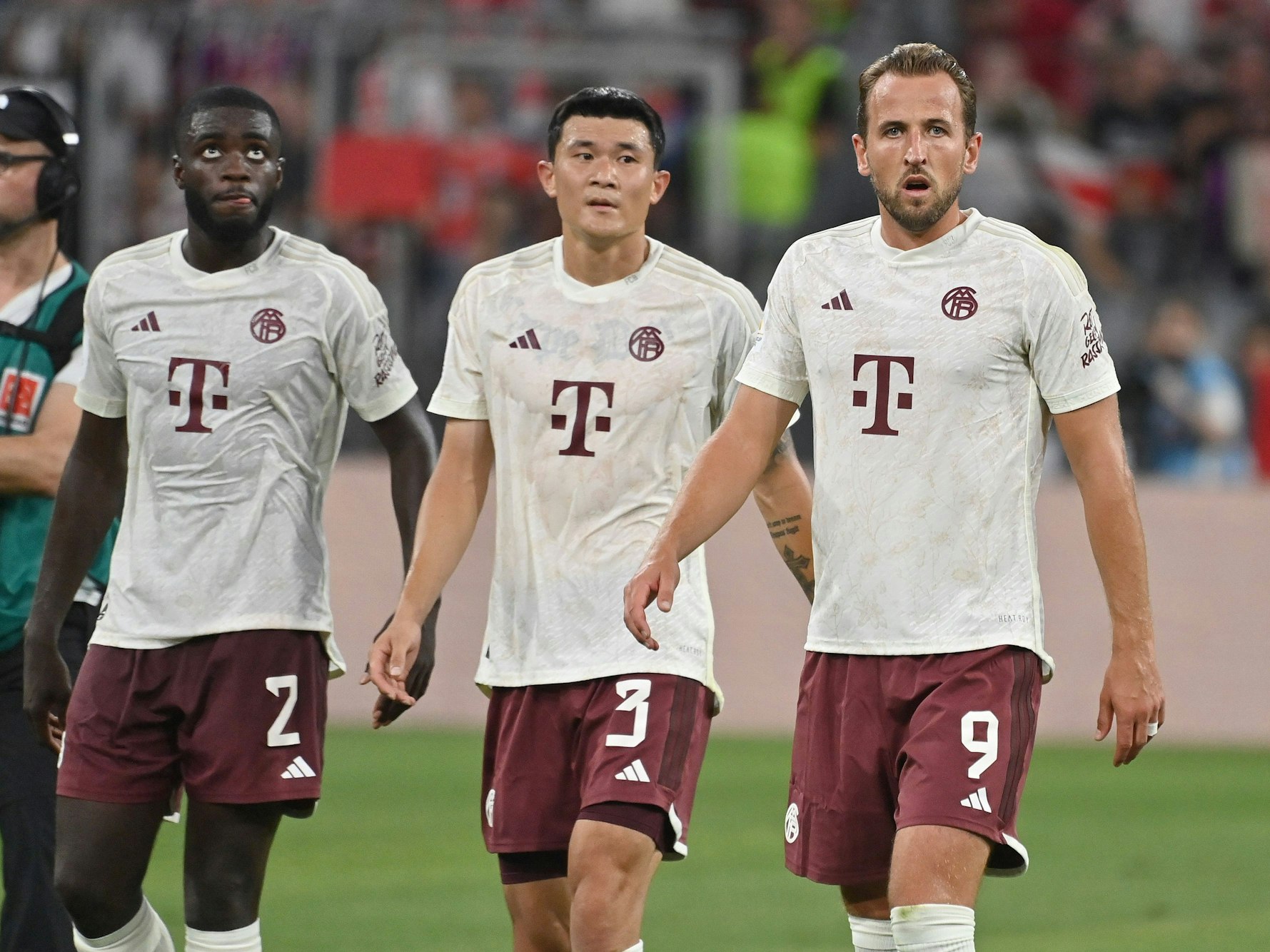 Dayot Upamecano, Min-Jae Kim und Harry Kane, alle vom FC Bayern München, laufen frustriert über den Platz.