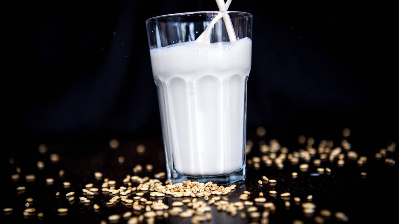 Hafermilch wird in ein Glas geschüttet.