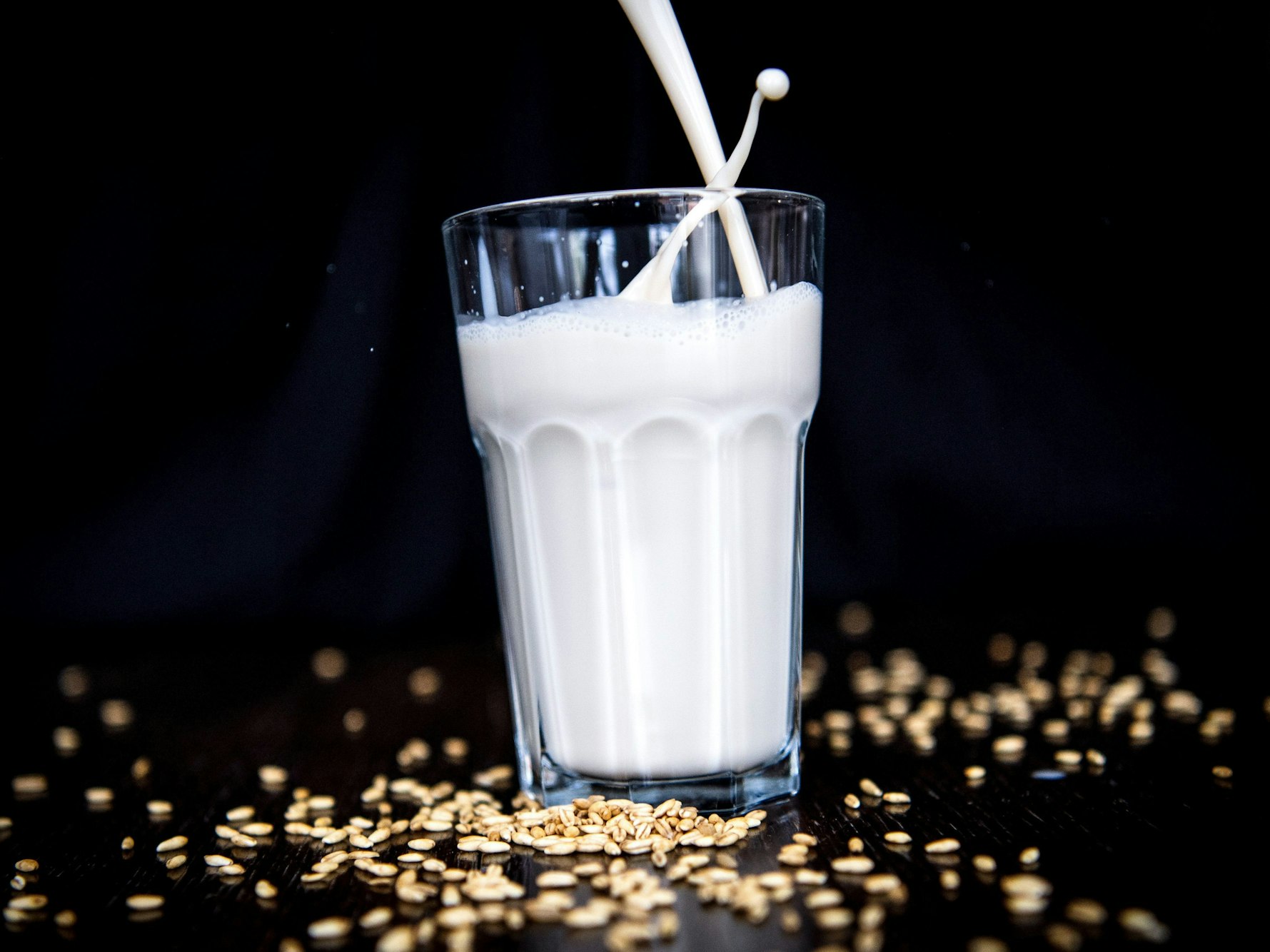 Hafermilch wird in ein Glas geschüttet.