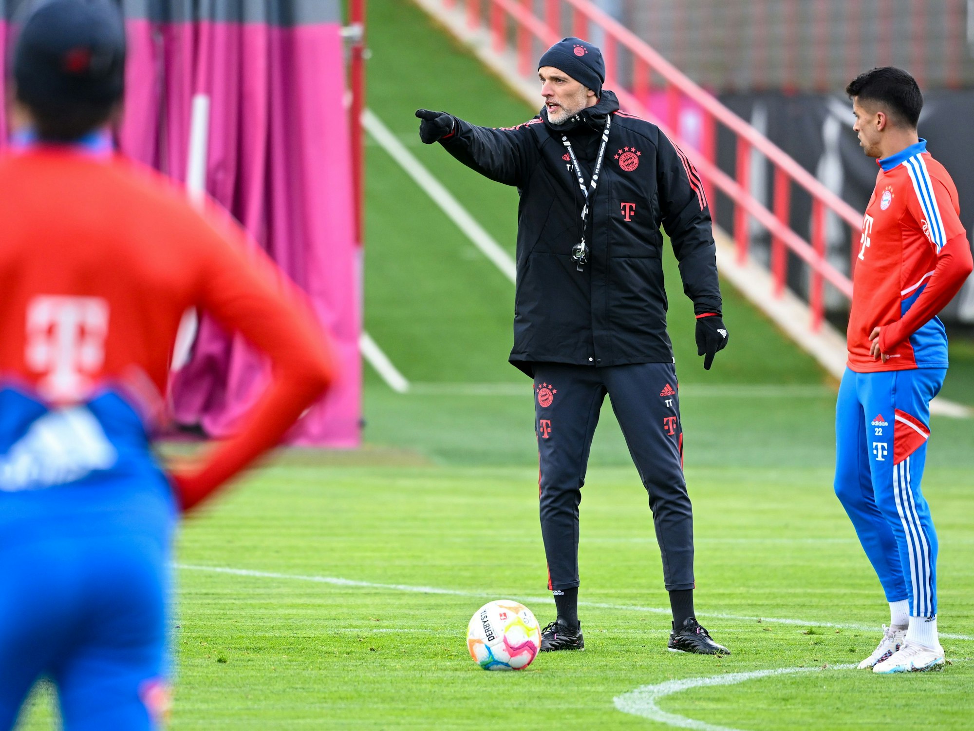Bayern-Trainer Thomas Tuchel steht bei seinem ersten Training gestikulierend neben Joao Cancelo (r).