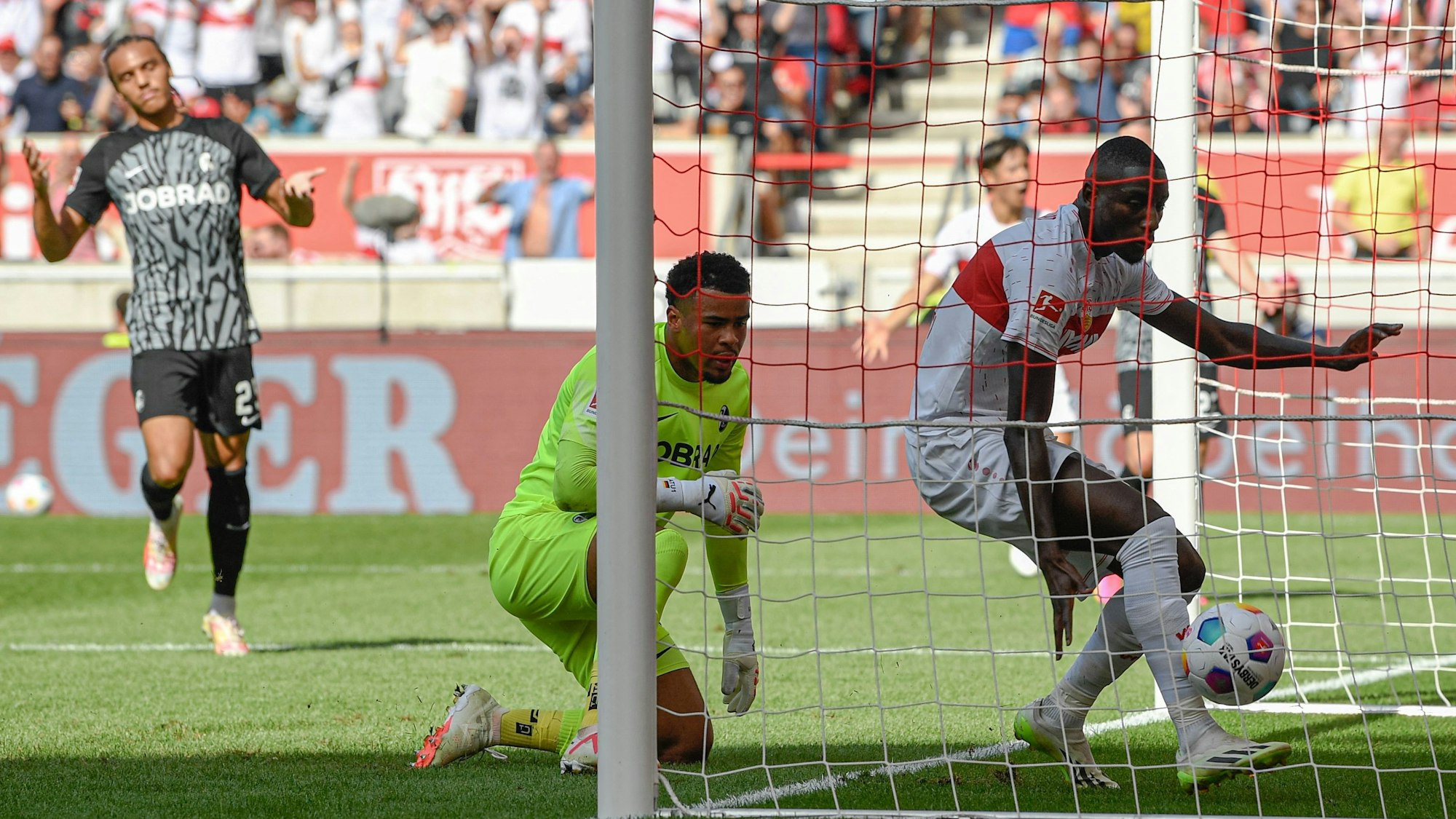 Serhou Guirassy steht mit dem Ball nach seinem Tor gegen den SC Freiburg im gegnerischen Kasten.