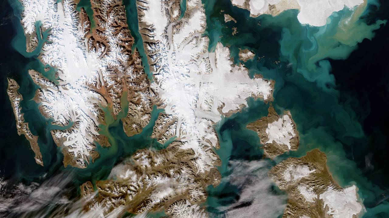 Die von der Europäischen Weltraumorganisation Esa mit modifizierten Copernicus-Sentinel-Daten (2022) verarbeitete Satellitenaufnahme zeigt die ungewöhnlich wolkenfreie Inselgruppe Svalbard: Die größte ist Spitzbergen (l.), gefolgt von Nordaustlandet (oben r.) und Edgeøya (unten r.). An einigen Orten auf Svalbard riecht es aktuell nach Schwefel.