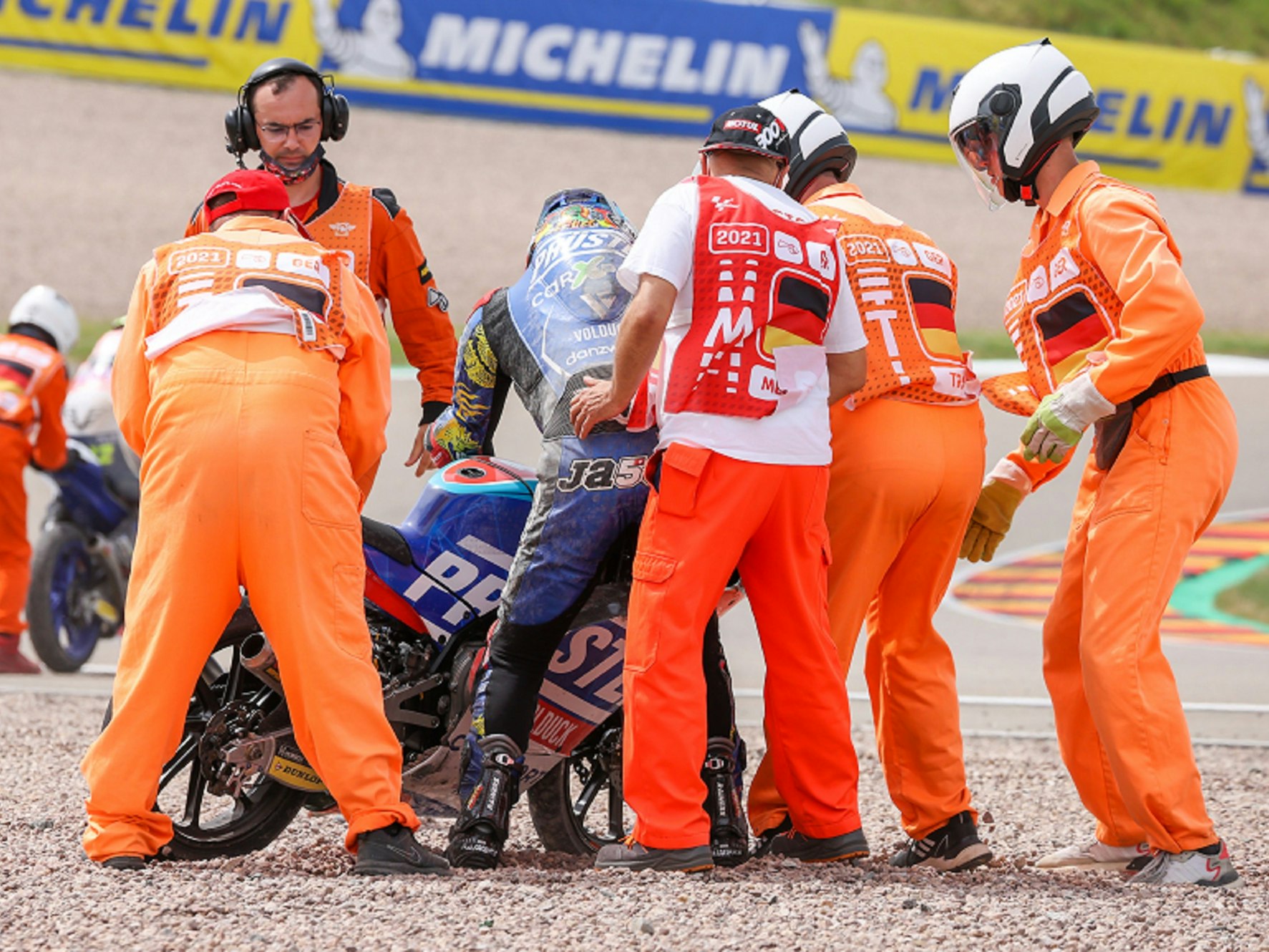 Streckenposten helfen dem Fahrer Ryusei Yamanaka aus Japan vom deutschen Team CarXpert PruestelGP nach einem Sturz. (20. Juni 2021)