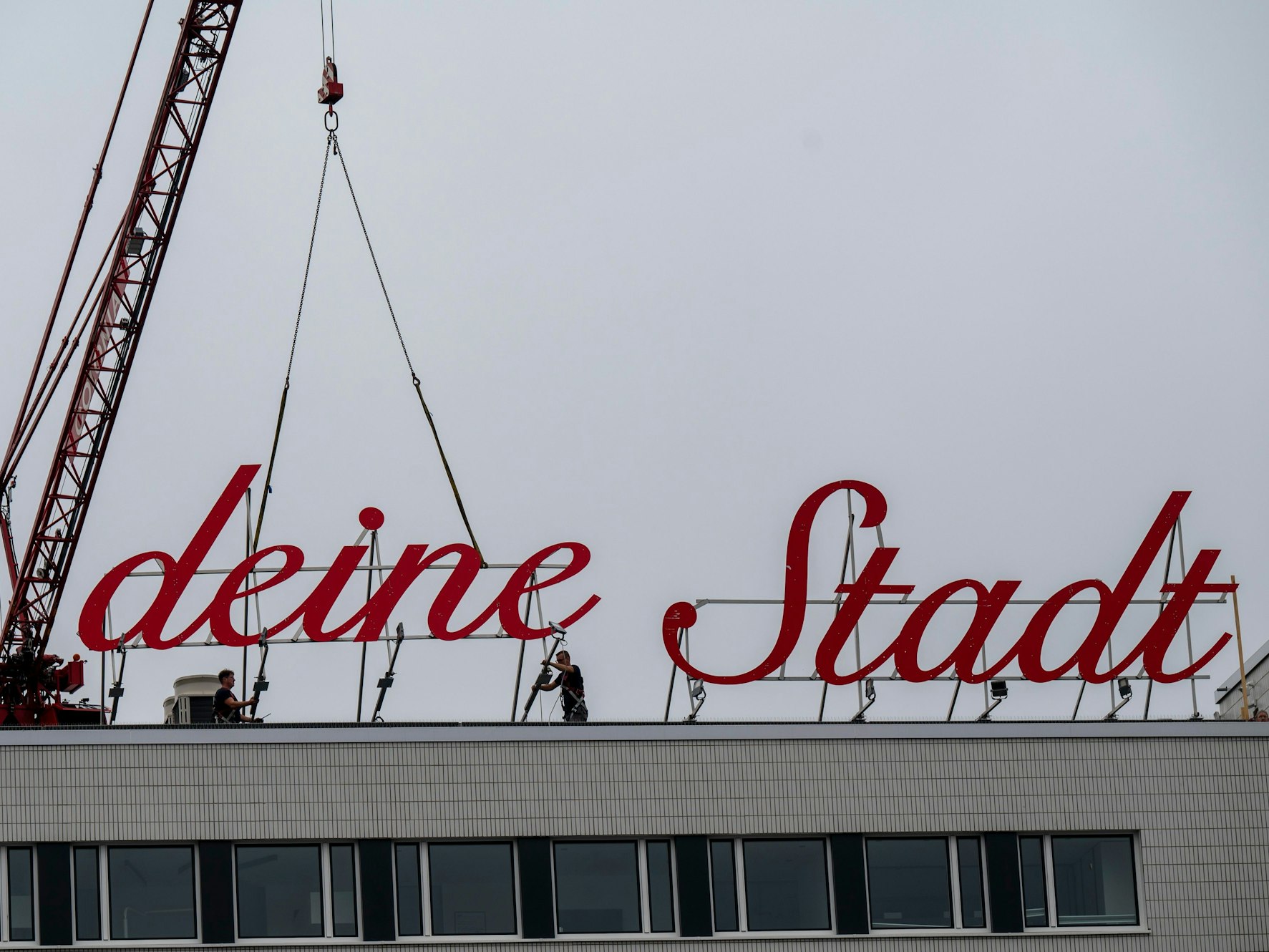Der Schriftzug „Liebe deine Stadt“ wird auf dem Dach befestigt.