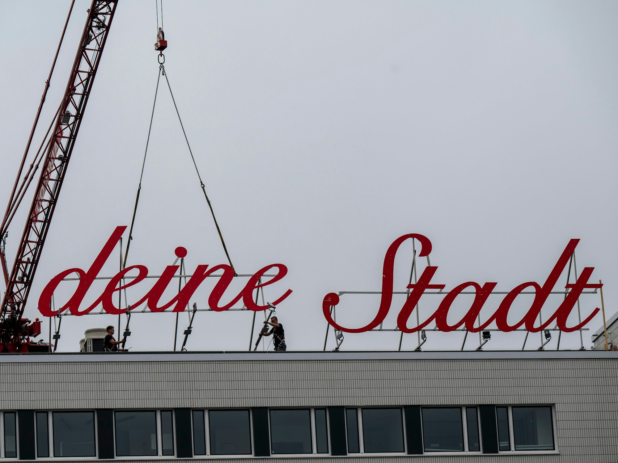 Der Schriftzug „Liebe deine Stadt“ wird auf dem Dach befestigt.