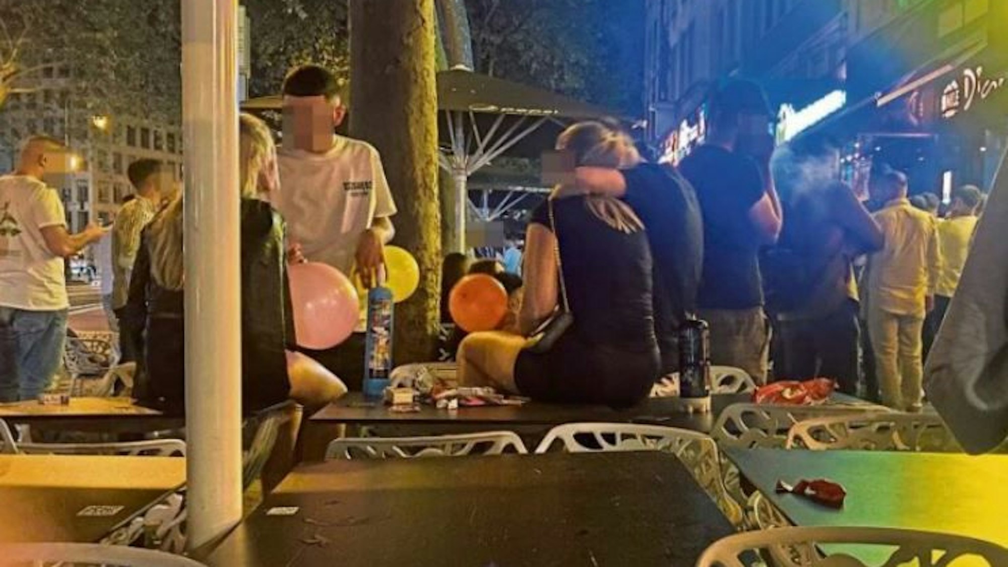 Gruppe Jugendlicher konsumiert Lachgas auf den Kölner Ringen.