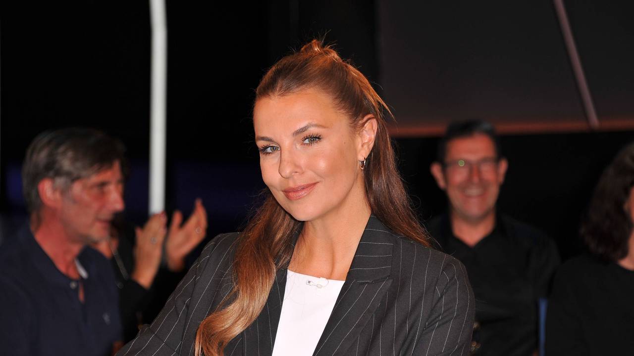 Laura Wontorra sitzt in einer TV-Runde und blickt in die Kamera.