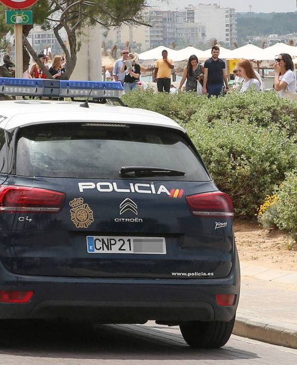 Ein Wagen der Policia Nacional fährt an der Playa de Palma auf Mallorca entlang.