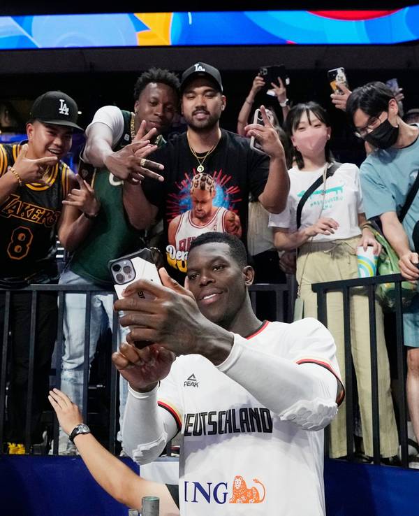 Dennis Schröder macht ein Selfie mit Fans.