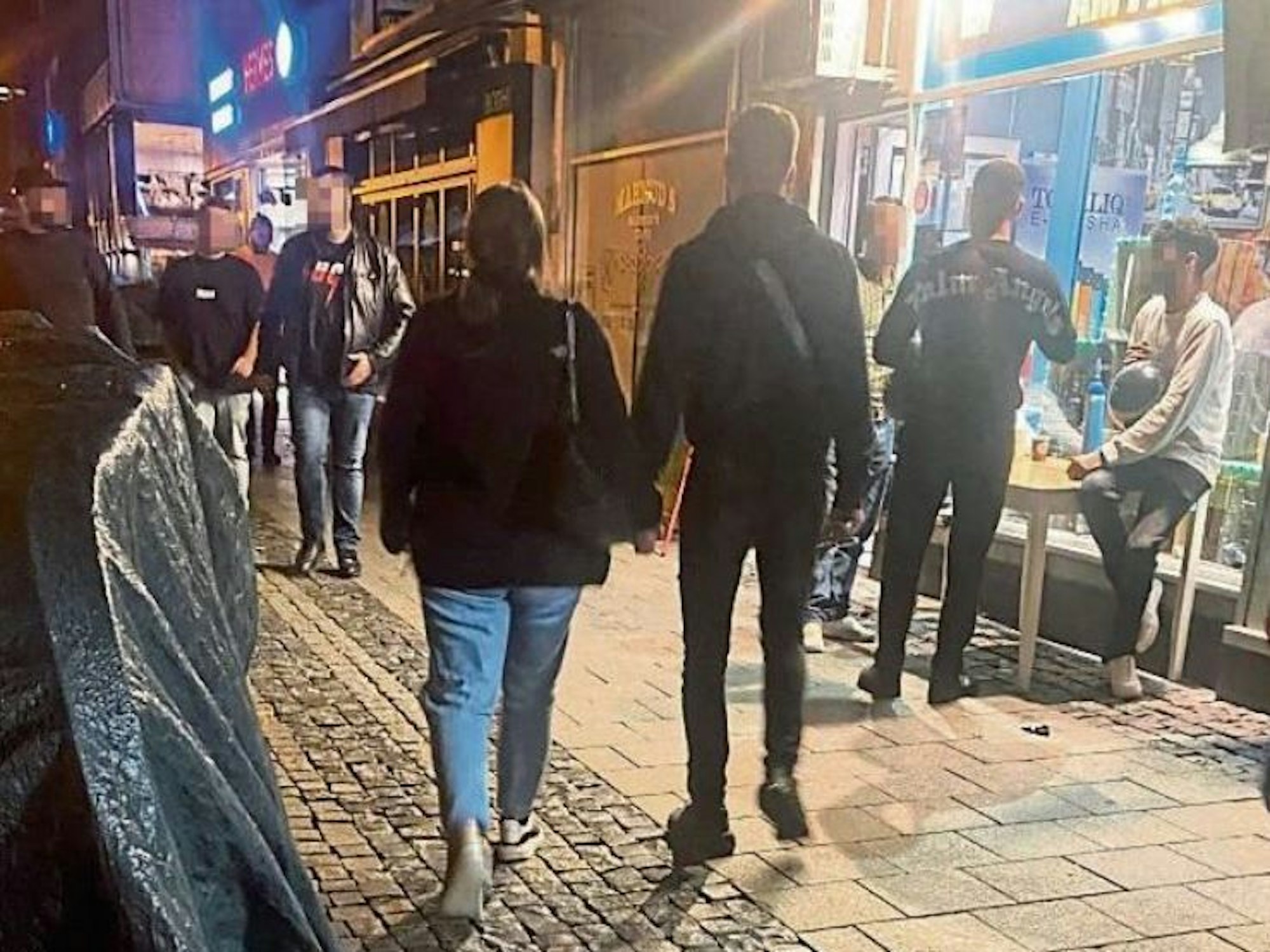 Mehrere Menschen vor einem Kiosk in Köln, einer davon hat einen Luftballon in der Hand und konsumiert Lachgas.