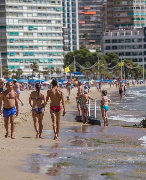 Menschen in Badekleidung an einem Strand in Spanien.
