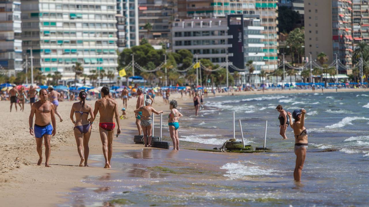 Menschen in Badekleidung an einem Strand in Spanien.