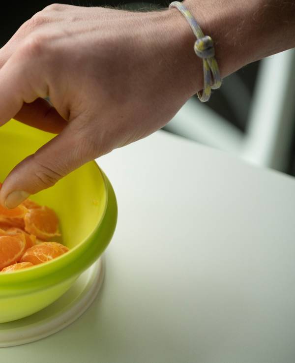 Mandarinen-Stücke in einem grünen Tupperware-Behälter.
