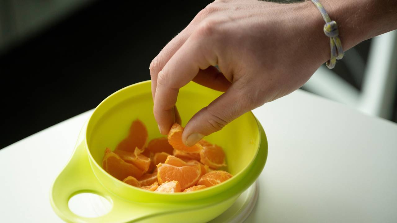 Mandarinen-Stücke in einem grünen Tupperware-Behälter.
