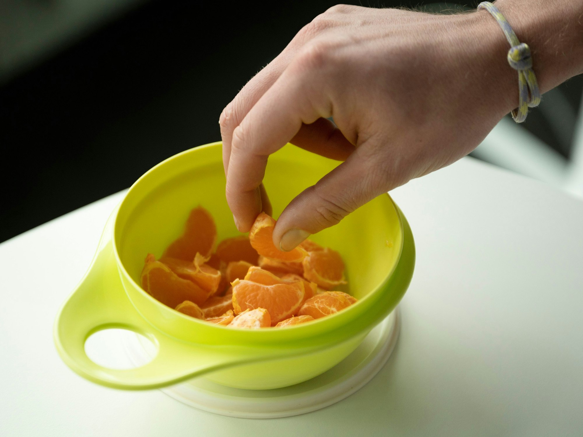 Mandarinen-Stücke in einem grünen Tupperware-Behälter.