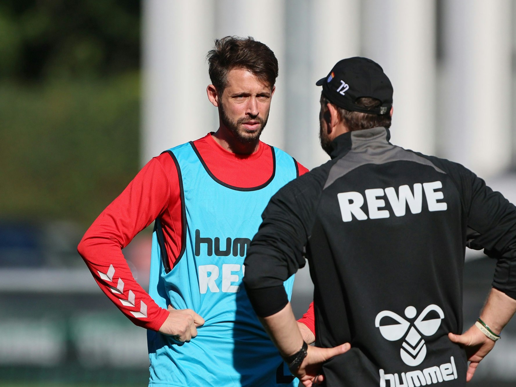 Mark Uth spricht im Training mit Steffen Baumgart.