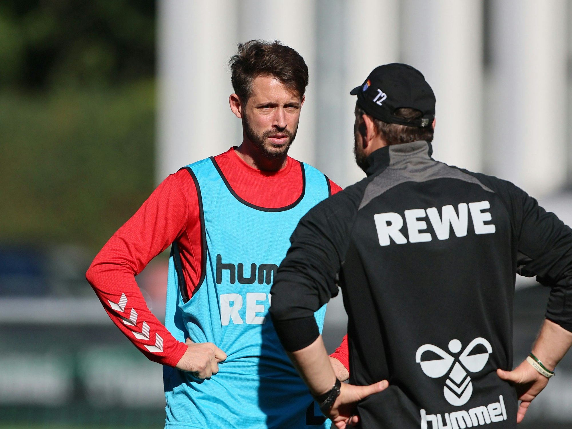 Mark Uth spricht im Training mit Steffen Baumgart.