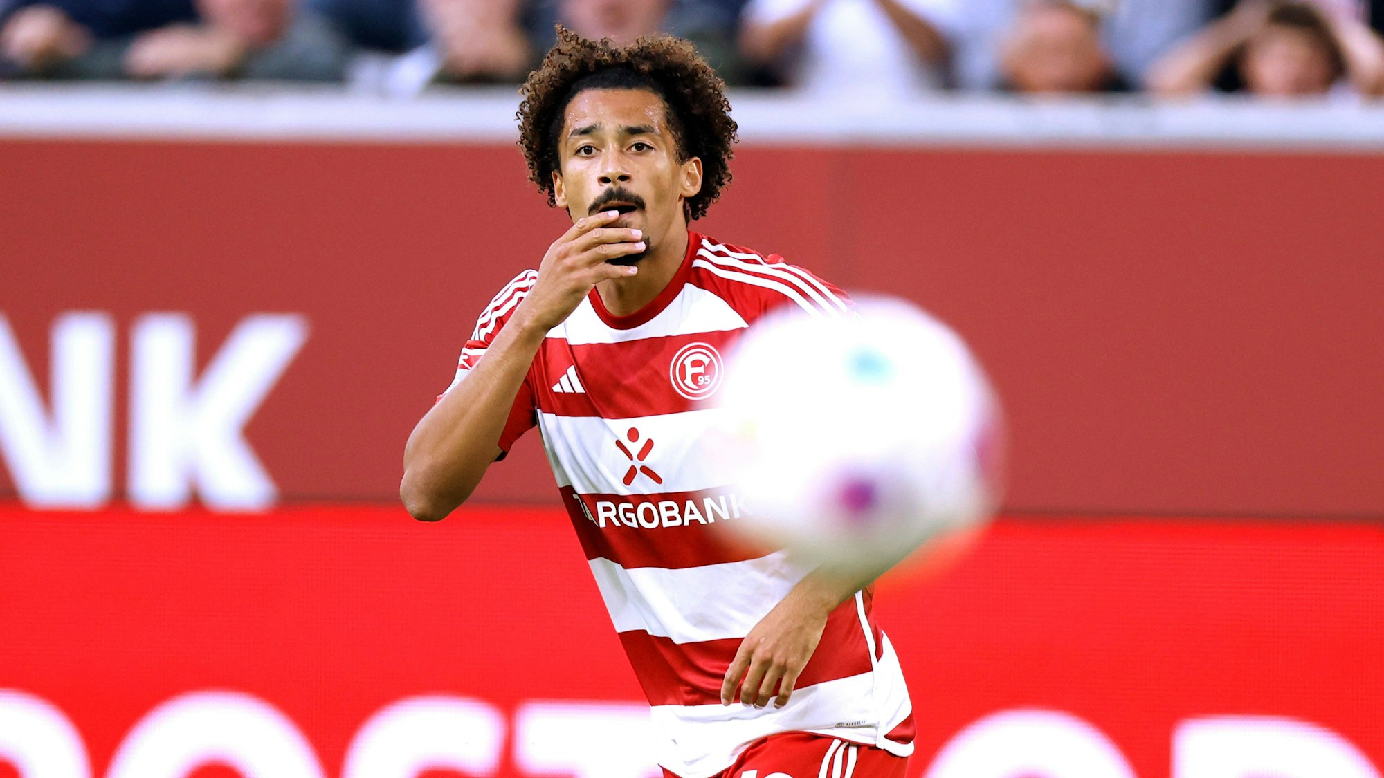 Emmanuel Iyoha fixiert im Spiel gegen den Karlsruher SC den Ball.