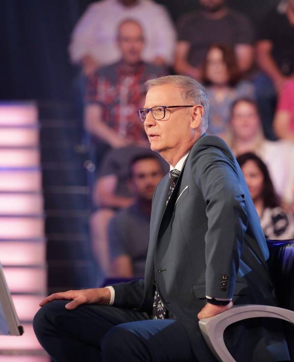 Moderator Günther Jauch sitzt auf einem Stuhl.