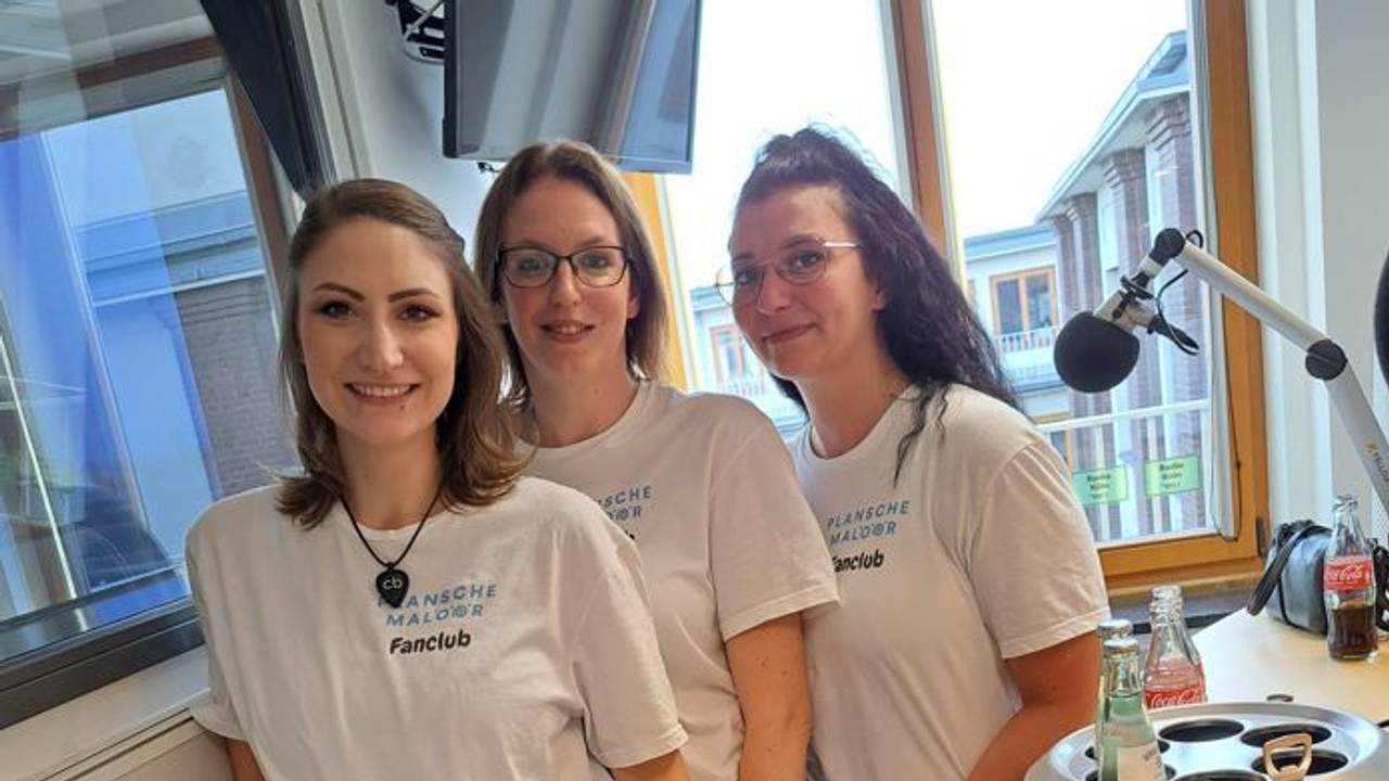 Drei Frauen stehen in einem Tonstudio und grinsen in die Kamera.