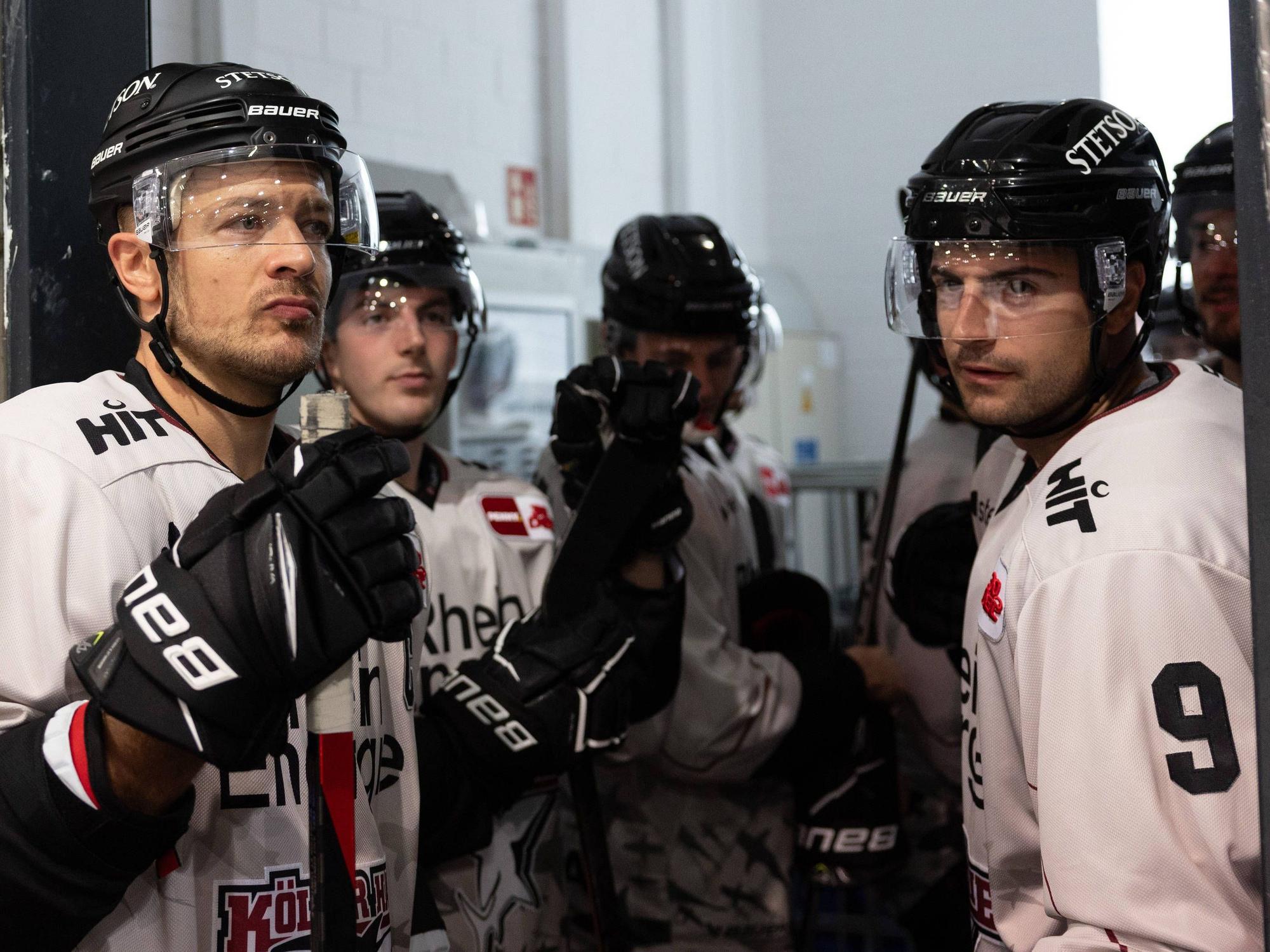 Die Spieler der Kölner Haie warten, bevor sie gegen die Düsseldorfer EG aufs Eisgehen dürfen.