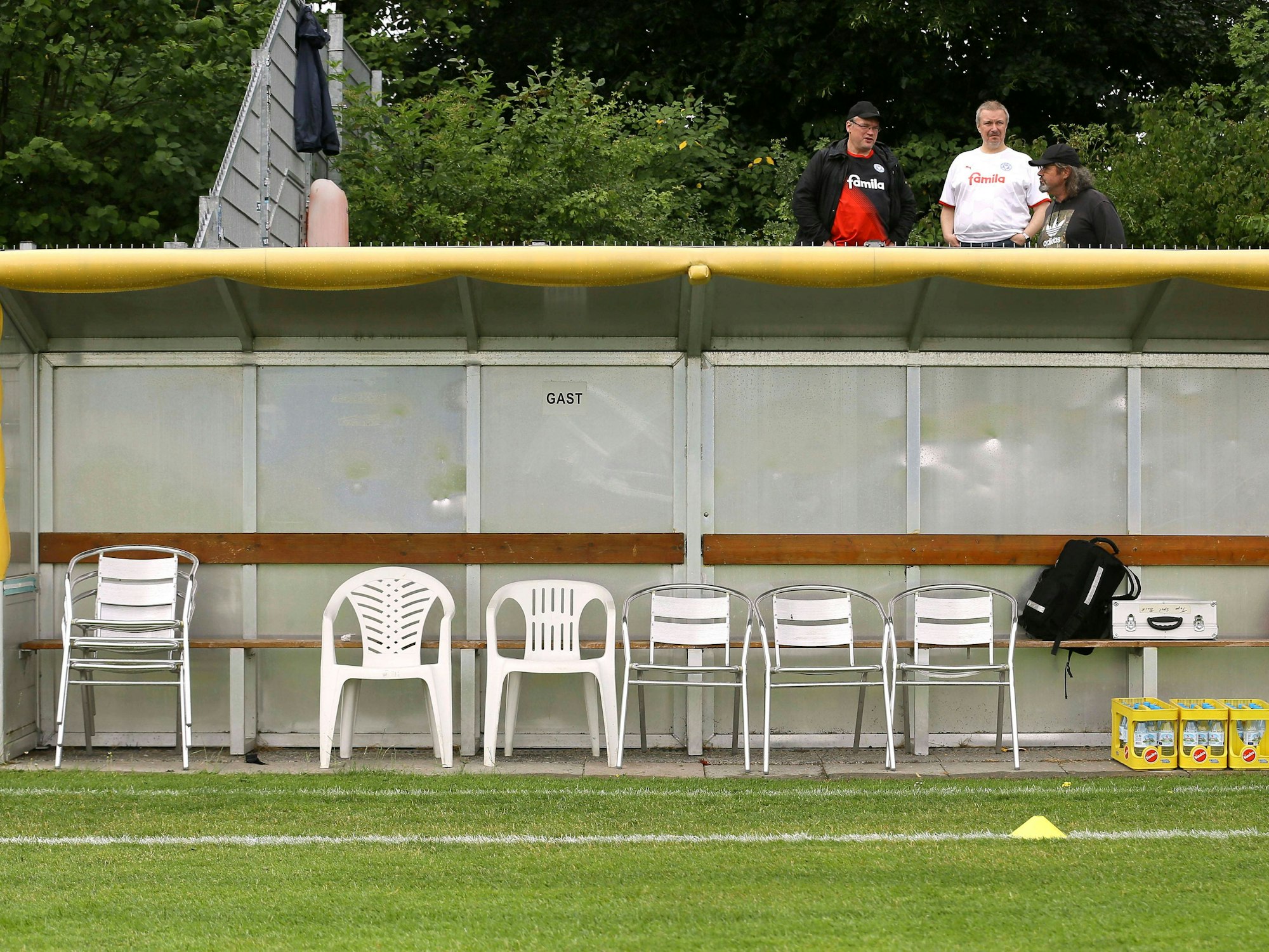 Eine leere Ersatzbank am Rande eines Fußball-Platzes,