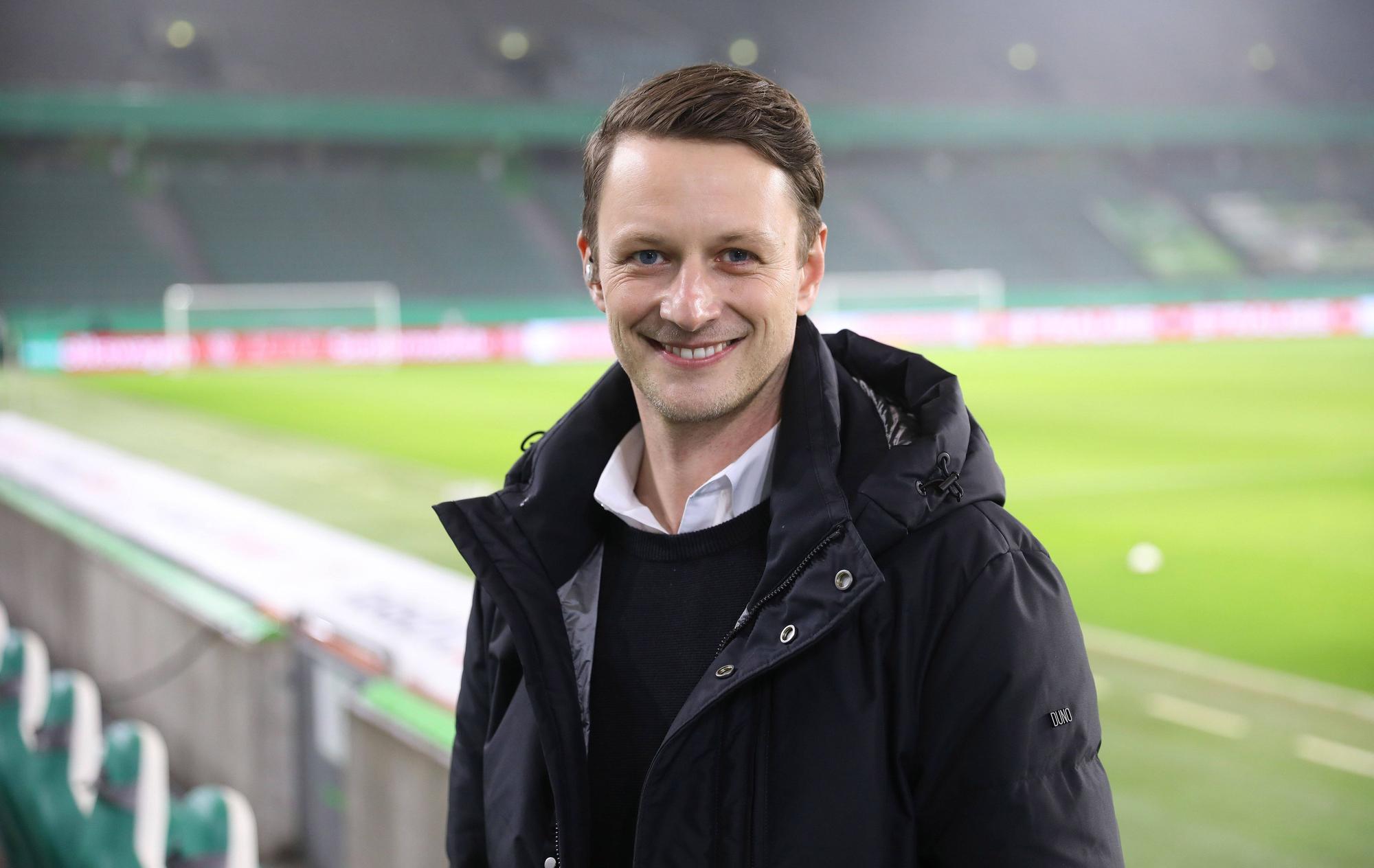 Jochen Stutzky posiert vor dem Pokalspiel zwischen Wolfsburg und Schalke auf der Tribüne für ein Porträtfoto.