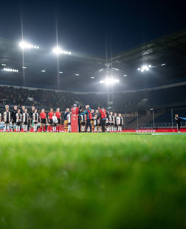 Die Mannschaften stehen vor dem Anpfiff auf dem Platz.