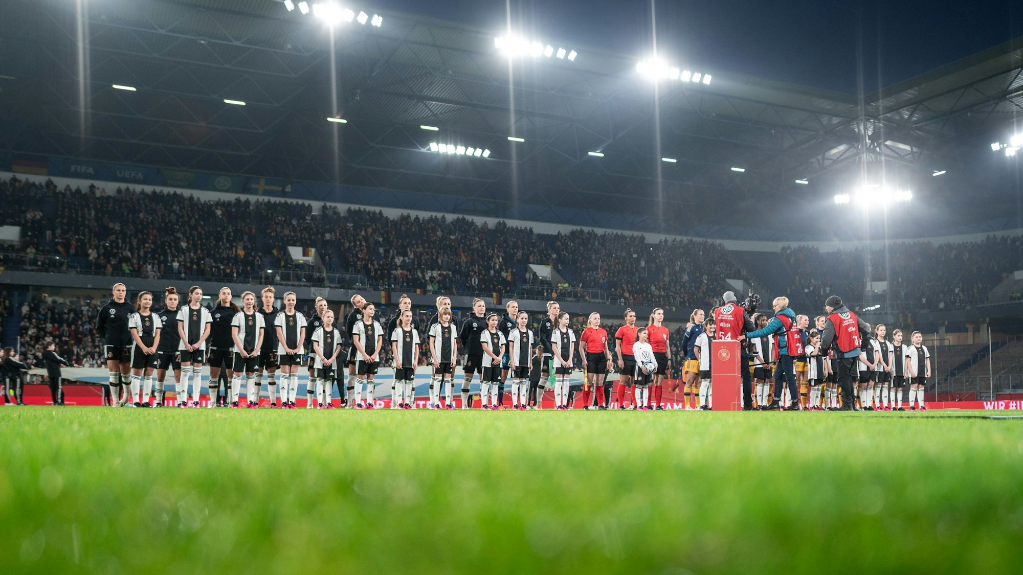 Die Mannschaften stehen vor dem Anpfiff auf dem Platz.