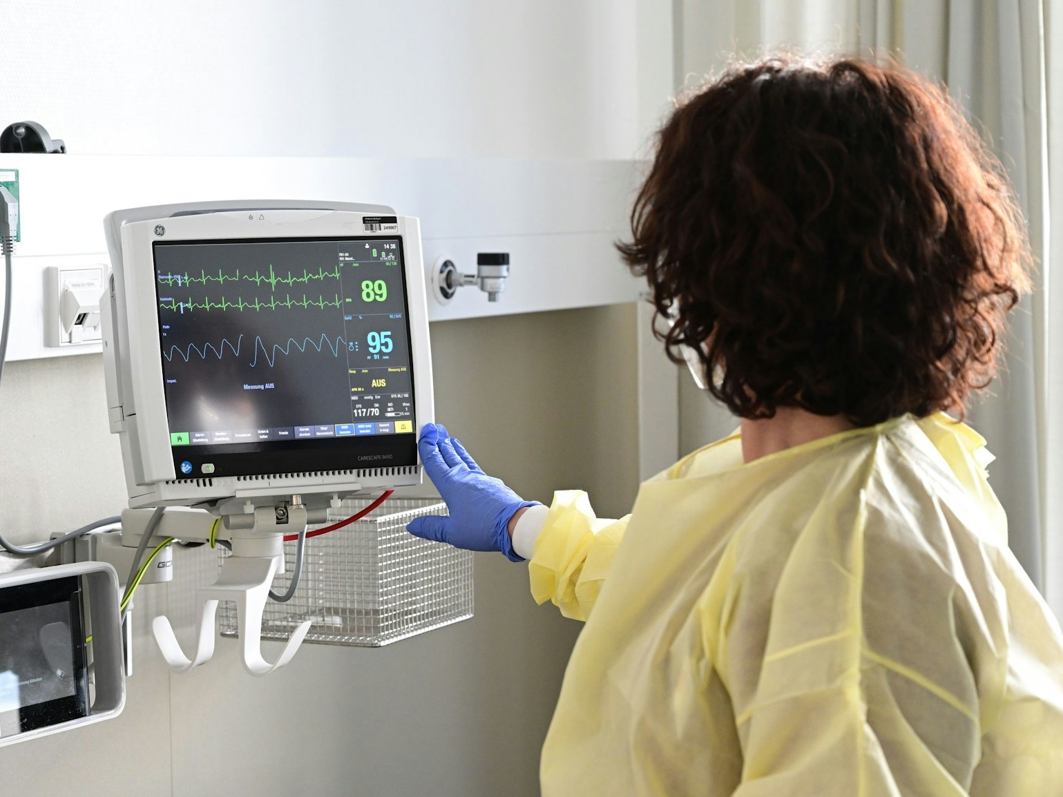 Eine Pflegerin schaut in einem Krankenzimmer im Klinikum Stuttgart auf einen Monitor einer Patientin, hier im Februar 2023.
